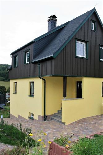 a yellow and black house with a black roof at Zum-Seiffener-Sprengmeister in Kurort Seiffen
