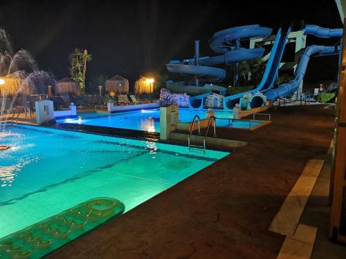 a swimming pool at night with a water slide at Sidari Waterpark in Sidari