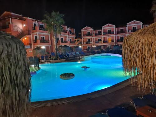 a large swimming pool in front of a hotel at night at Sidari Waterpark in Sidari
