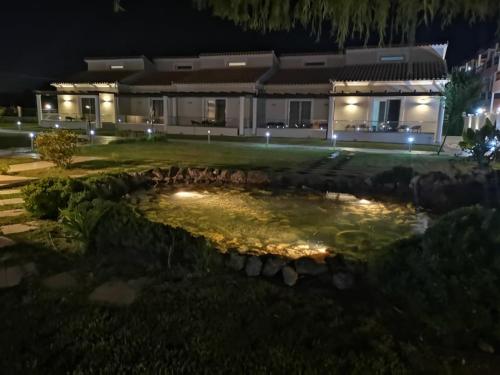 a pond in front of a house at night at Sidari Waterpark in Sidari