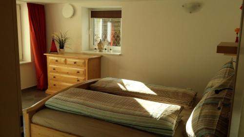 een kleine slaapkamer met een bed en een dressoir bij Ferienwohnung Valentin in Hohenpeißenberg