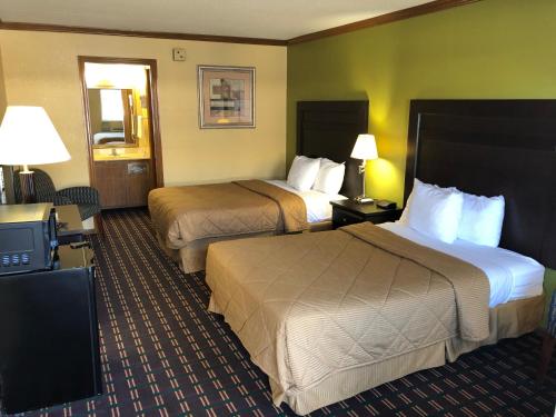 a hotel room with two beds and a television at Americas Best Value Inn Maumee/Toledo in Maumee