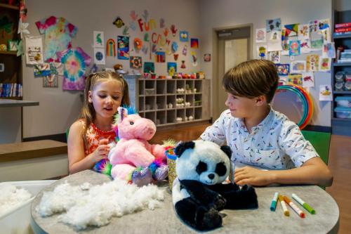 two children sitting at a table with stuffed animals at The Grove Resort & Water Park Orlando in Orlando