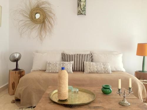 a bedroom with a bed with a wooden table with a table at Dar Alya Essaouira Maison et table d'hôtes in Ghazoua