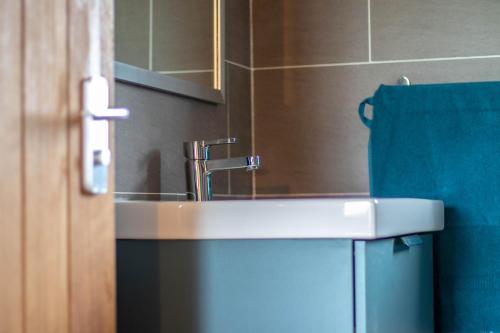 a bathroom with a sink and a blue towel at Seal Cottage in Portree