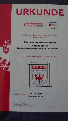 a white envelope with a red logo on it at Exklusiv Apartment Hofer in Sankt Johann in Tirol