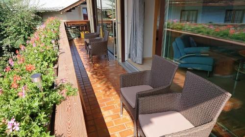a patio with chairs and flowers on a balcony at Exklusiv Apartment Hofer in Sankt Johann in Tirol