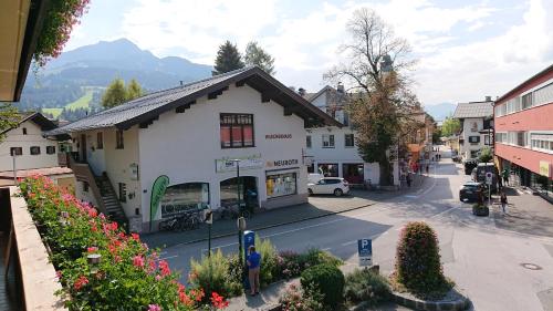 a small white building on a street in a town at Exklusiv Apartment Hofer in Sankt Johann in Tirol