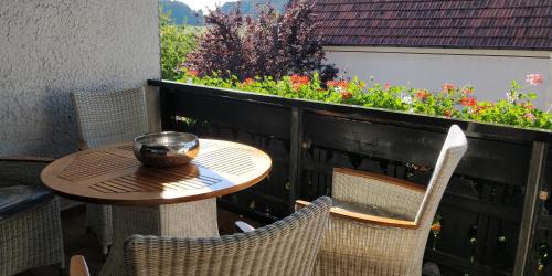 een tafel en stoelen op een patio met bloemen bij Ursula's Ferienwohnung in Marpingen