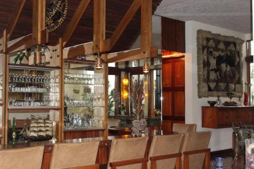 a bar in a restaurant with chairs and a counter at Casa Mora B&B in Cartago