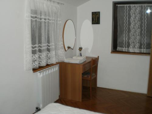 a bedroom with a mirror and a table with a mirror at APARTMANI SENKA - VILLA OLIVER in Martinšćica