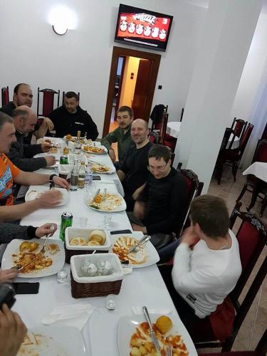 a group of people sitting at a table eating food at Pensiunea Mayumi Moneasa in Moneasa