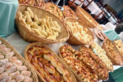 a table topped with baskets of bread and pastries at Ilhas do Lago Eco Resort by WAM Experience in Caldas Novas