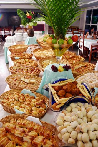 a table filled with baskets of bread and pastries at Ilhas do Lago Eco Resort by WAM Experience in Caldas Novas