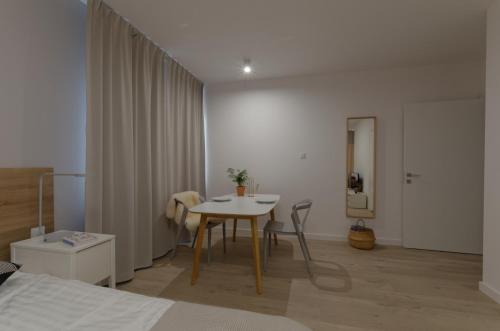 sypialnia ze stołem i pokój z łóżkiem w obiekcie Apple Green Apartments w Poznaniu