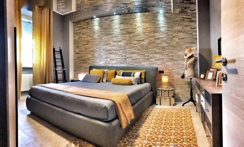 una camera con letto e muro di mattoni di Appartamento La Paleologa a Casale Monferrato