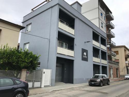 a white building with a car parked in front of it at nautilus b&b suite design in Follonica