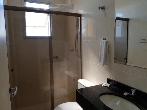 a bathroom with a shower and a sink and a toilet at Astro Hotel in São José dos Campos