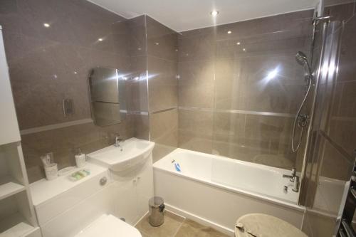 e bagno con vasca, servizi igienici e lavandino. di Holden Court Apartments - Apt 3 a West Drayton