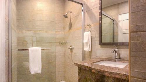 ein Bad mit einer Dusche, einem Waschbecken und einem Spiegel in der Unterkunft Only 350 yards from Eagle Beach! in Palm-Eagle Beach