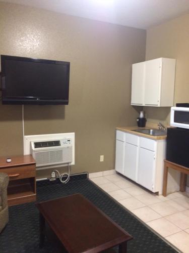 a living room with a kitchen with a tv and a table at Holland Inn and Suites in Taft
