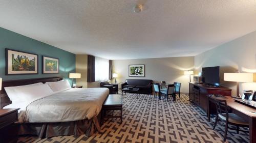 Una habitación de hotel con una cama, un escritorio y sillas. en Bear Claw Casino & Hotel, en Kenosee Park