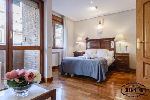 Un dormitorio con una cama y una mesa con un jarrón de flores en Charming Argüelles, en Madrid