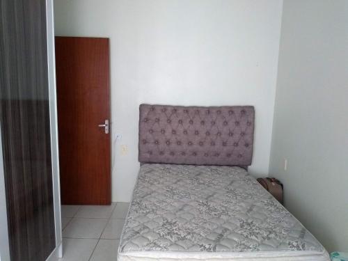 a small bedroom with a bed with a purple headboard at Casa de férias in Governador Celso Ramos