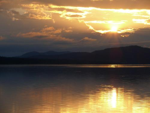a sunset over a large body of water at Stora Björnstugan in Laisvall