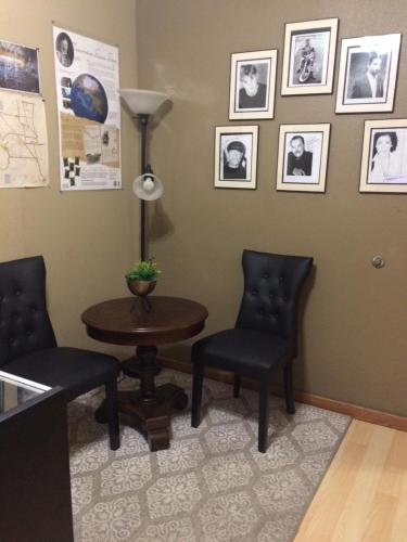 a waiting room with two chairs and a table at Holland Inn and Suites in Taft