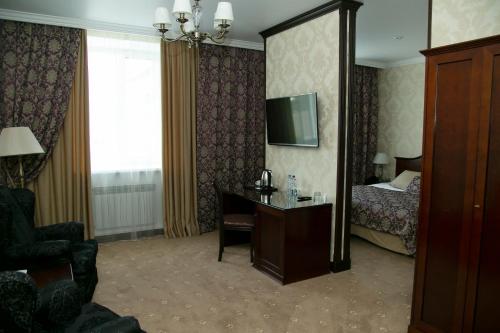 a hotel room with a bedroom with a bed and a desk at Forum in Tomsk