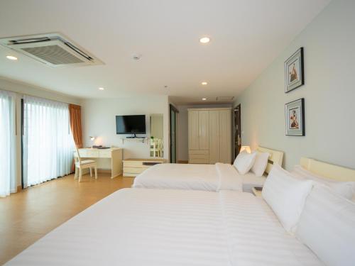 una camera d'albergo con 2 letti e una scrivania di The Kinn Bangkok a Bangkok