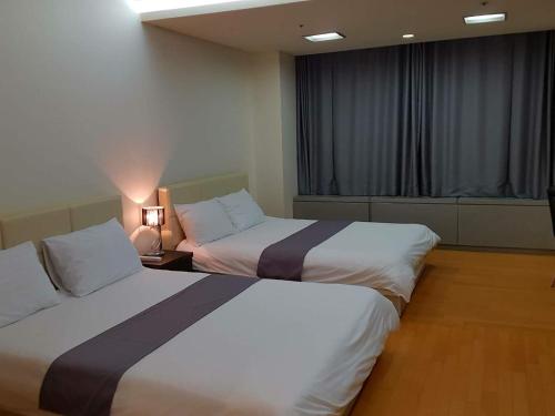 a hotel room with two beds and a window at Sky Guestel in Incheon