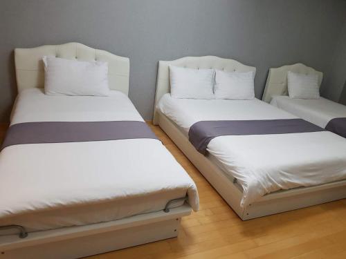 two beds sitting next to each other in a room at Sky Guestel in Incheon