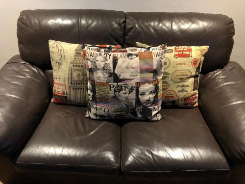 a leather couch with three pillows on it at LOFT PREMIUM Boa Viagem 20 andar in Recife