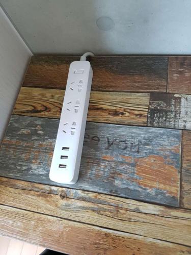 a remote control sitting on top of a wooden wall at Sky Guestel in Incheon