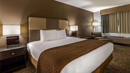 a hotel room with a large bed and a chair at Best Western Yuba City Inn in Yuba City