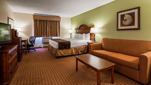 a hotel room with a bed and a couch and a tv at Best Western York Inn in York