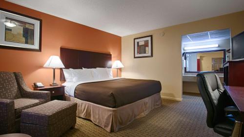 a hotel room with a bed and a chair at Best Western Markita Inn in Durant