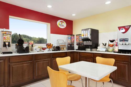 a coffee shop with a white table and yellow chairs at Super 8 by Wyndham Corsicana in Corsicana