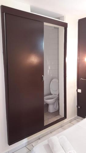 a bathroom with a door with a toilet in it at Hôtel Du Centre in Saint-Denis