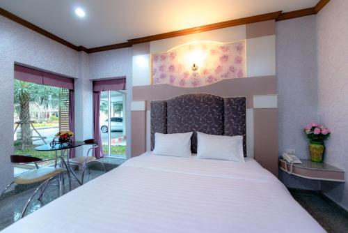 a bedroom with a large bed and a balcony at Martina Hotel Surin in Surin