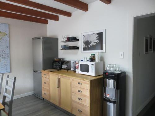 a kitchen with a counter with a microwave and a refrigerator at At Wits End B&B in Banff