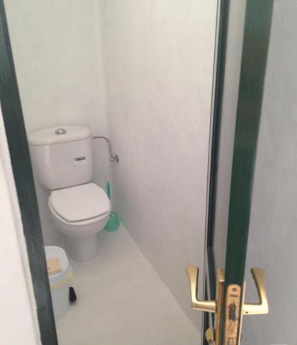 a small bathroom with a toilet in a room at Patio II studio at finca in La Asomada