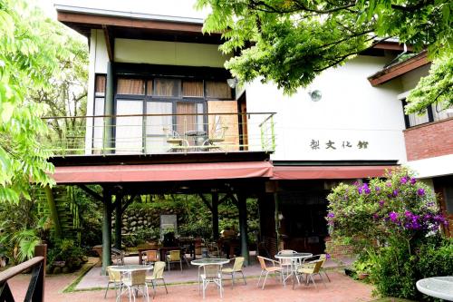 a patio with tables and chairs in front of a building at Pear Story House in Dongshi