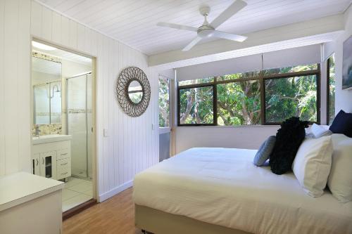 Habitación blanca con cama y ventana en Tea Trees, en Noosa Heads