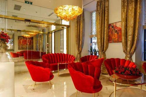 a waiting room with red chairs and a mirror at Boutiquehotel Das Tyrol in Vienna