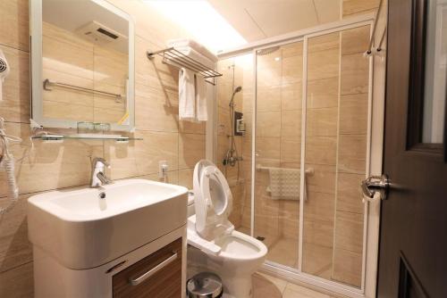 W łazience znajduje się umywalka, toaleta i prysznic. w obiekcie Kinmen Yu Yuan w mieście Jincheng