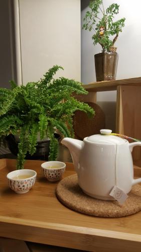 a tea pot and two bowls on a table with plants at Ze Hu B&B in Yuchi
