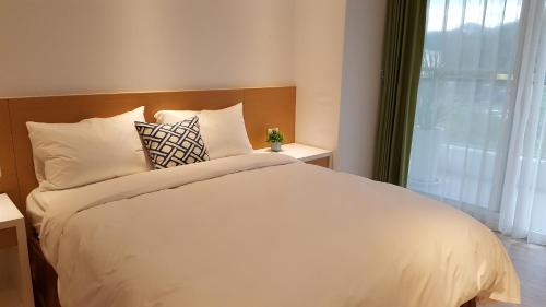 a bedroom with a white bed and a window at Ze Hu B&B in Yuchi